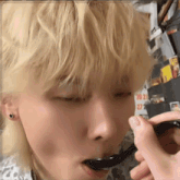 a person is holding a black spoon in their mouth
