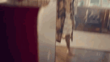 a woman is walking through a doorway in a room .
