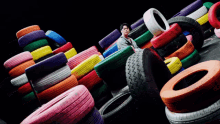 a man stands in front of a pile of tires