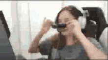 a woman is wearing headphones while sitting in front of a laptop .