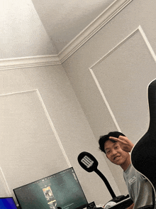 a man sitting in front of a computer with a shirt that says armani