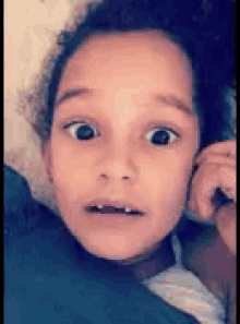 a young girl with a surprised look on her face .
