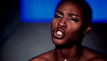 a close up of a woman 's face with a cross necklace on her neck