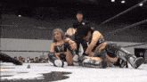 two women are wrestling in a ring and one is wearing a belt that says jc