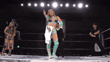 a woman in a wrestling ring giving a thumbs up with the number 2 behind her