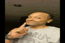 a man wearing a shirt that says abercrombie is pointing at his face