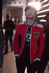 a man wearing a red jacket that says t1 on it