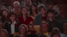 a man is taking a picture of a crowd of people in a theatre .