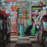 a woman sits in a store with a sign that says ' candy '