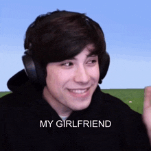 a young man wearing headphones is smiling with the words my girlfriend below him