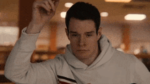 a man wearing a white hoodie with a red and white striped sleeve