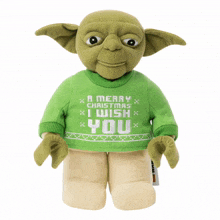 a stuffed toy of yoda wearing a green sweater that says a merry christmas i wish you