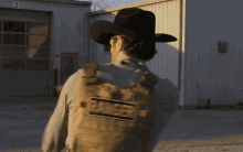 a man in a cowboy hat is wearing a vest that says ranger