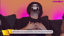 a man with a skull mask on his face is sitting on a couch with his hands on his chest