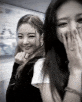 a couple of girls are standing next to each other and smiling .