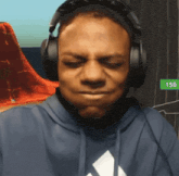 a man wearing headphones and a blue adidas hoodie