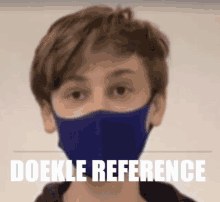 a young boy wearing a purple face mask with the words doekle reference written on the bottom .
