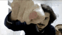 a man with a mustache is holding a piece of paper in his hand