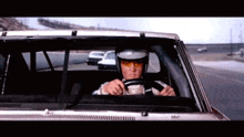 a man in a helmet is driving a car on a road
