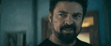 a man with a beard and mustache is smiling and looking at the camera