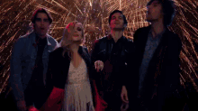 a group of people dancing in front of fireworks .