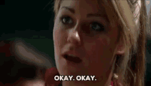 a close up of a woman 's face with the words `` okay okay '' written next to her .