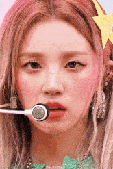 a close up of a girl with a microphone in her mouth