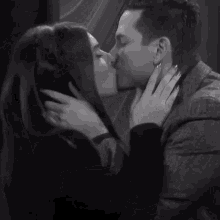 a man and a woman kissing in a black and white photo