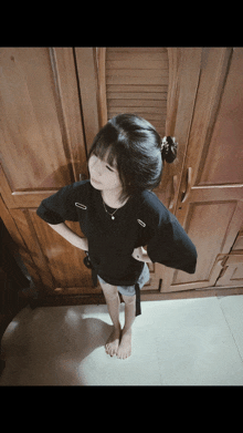 a girl standing in front of a wooden closet
