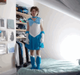 a person dressed in a blue sailor moon costume stands on a bed