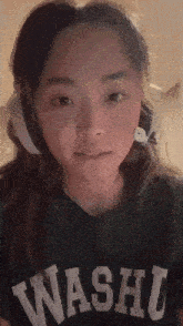 a woman wearing headphones and a black shirt that says washu