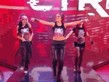 three women are dancing on a stage in front of a sign that says ' starr '