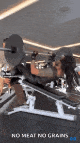a woman is lifting a barbell in a gym while wearing a mask .
