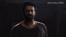 a man with a beard in a dark room with the hashtag avantika_0902 on the bottom