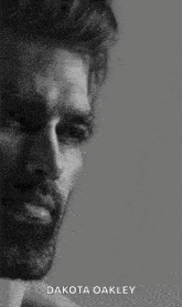 a black and white photo of a man with a beard and the words `` dakota oakley '' on the bottom .