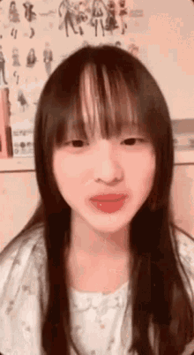 a close up of a woman 's face with long hair and bangs .