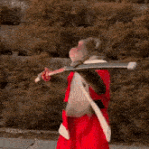 a monkey wearing a santa claus costume is holding a sword .