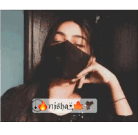 a girl wearing a black face mask with the name nisha on it