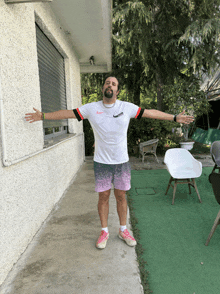 a man with his arms outstretched is wearing a white nike shirt