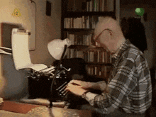 a man in a plaid shirt is typing on a typewriter in front of a sign that says 12