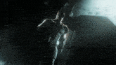 a man in a black suit is standing in the dark