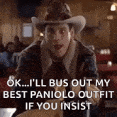a man wearing a cowboy hat and gloves is sitting at a table in a restaurant and talking .