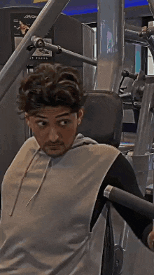 a man is using a machine in a gym that says press on it .