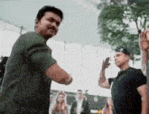 a man in a green shirt is dancing with another man in a black shirt .