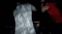 a blurry picture of a man in a red shirt and a man in a white shirt