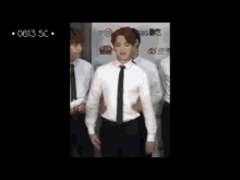 a man in a white shirt and black tie is being held by another man