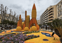 a rocket made out of oranges sits in a garden