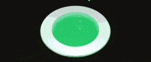 a white circle with a green liquid in it