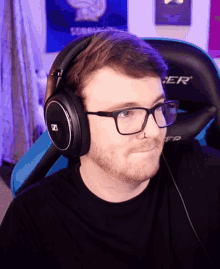 a man wearing glasses and headphones is sitting in a chair that says dxr on it