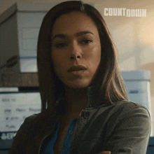 a woman stands with her arms crossed in front of a sign that reads countdown